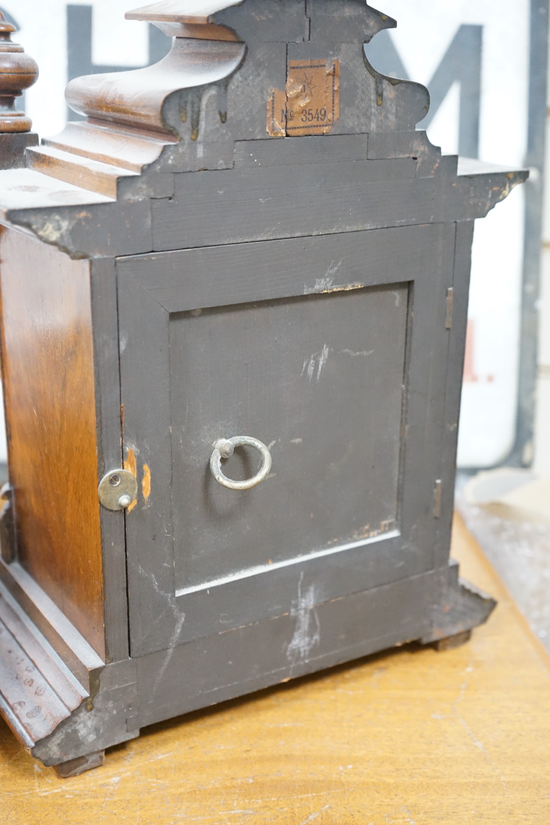 A 19th century German walnut mantel clock with key and pendulum, 40cm tall